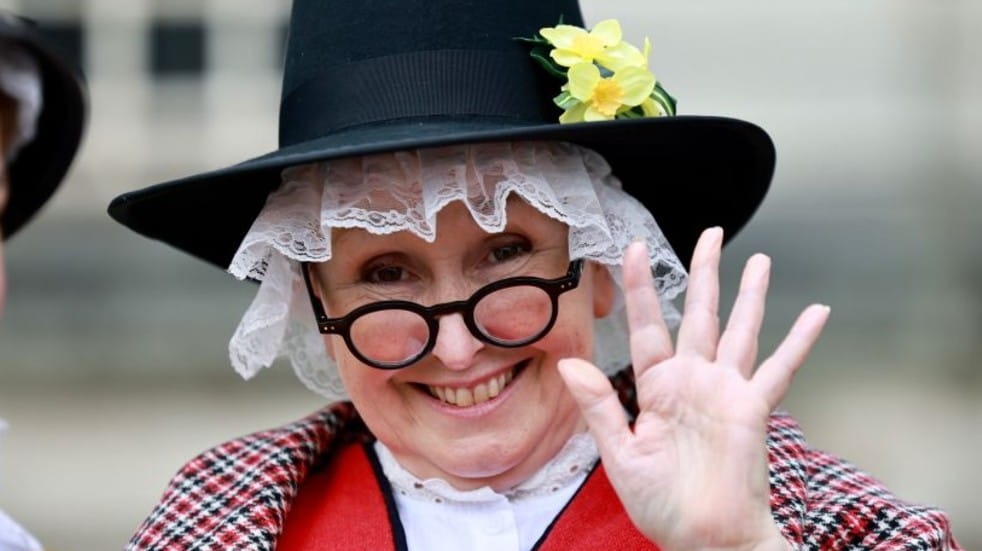Woman in Welsh costume waving